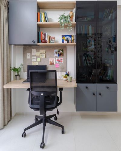Home study nook with floating wood desk, black mesh chair, and grey shelving units.