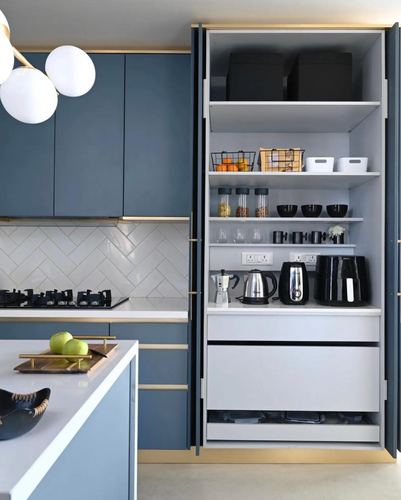 Blue kitchen cabinetry with open pantry unit showing organized shelves and appliances