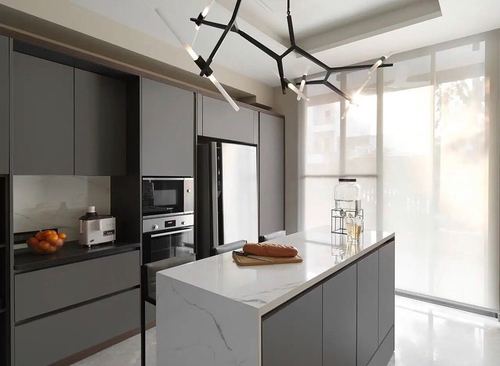 Modern grey kitchen with marble island, black branching chandelier, and sheer-curtained window wall