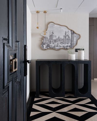 Black entryway with arched console table, framed cityscape art, and geometric marble floor.
