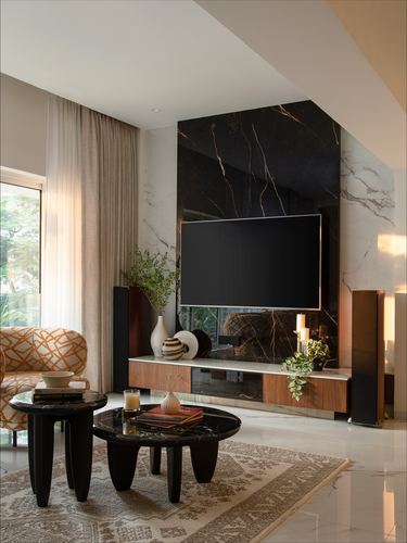 Living room with dark marble TV wall, wood console, black round coffee tables and sheer curtains