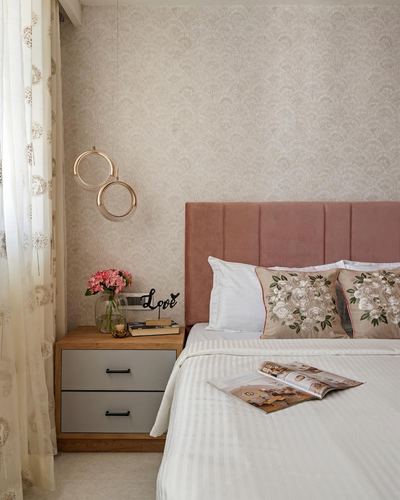 Bedroom with pink channel-tufted headboard, floral wallpaper, and round pendant lights over nightstand