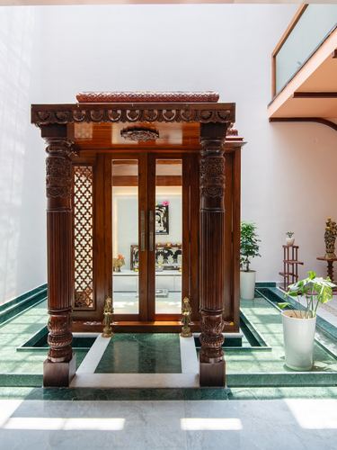 Carved wooden entrance porch with pillars and glass doors set over a green marble water channel
