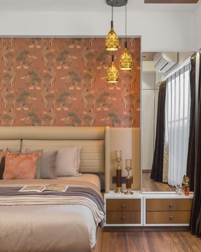 Bedroom with terracotta animal-print wallpaper, upholstered headboard, and cluster of lantern pendants over nightstands