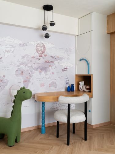 Child's study nook with map mural, curved wooden desk on blue turned leg, and boucle stool