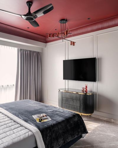 Bedroom with ribbed red ceiling, wall-mounted TV, and black-and-brass console