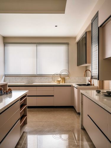 Beige L-shaped modern kitchen with marble-look countertops, island, and fluted glass cabinets