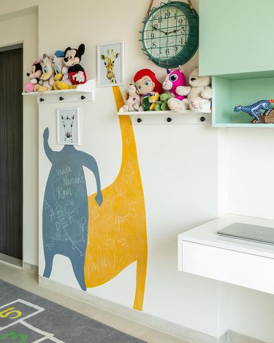 Kids' room wall with yellow and grey chalkboard animal mural, toy-lined shelves and a wall clock