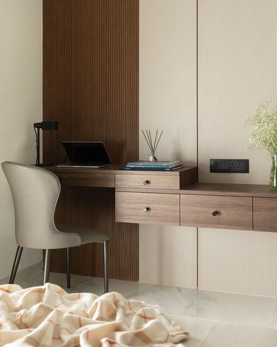 Floating wooden desk with laptop against fluted wood and ribbed wall panels