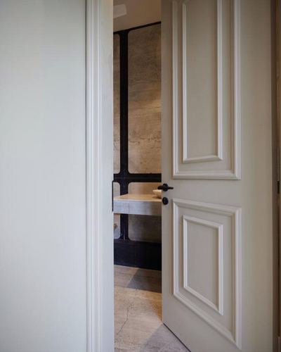 Half-open white panelled door revealing a stone bathroom counter beyond