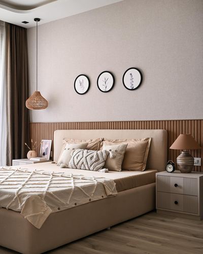 Beige bedroom with upholstered bed, fluted wood panelling and three round framed prints above headboard