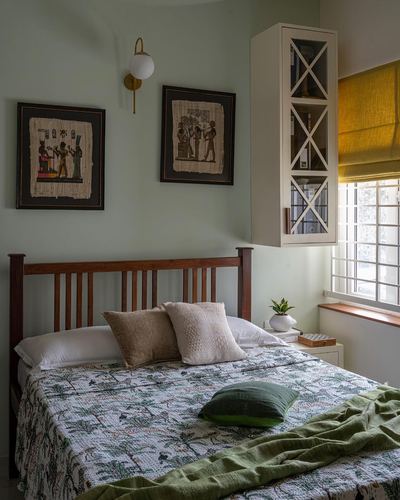 Bedroom with sage walls, slatted wood headboard, papyrus art, mustard blind, and green kantha quilt
