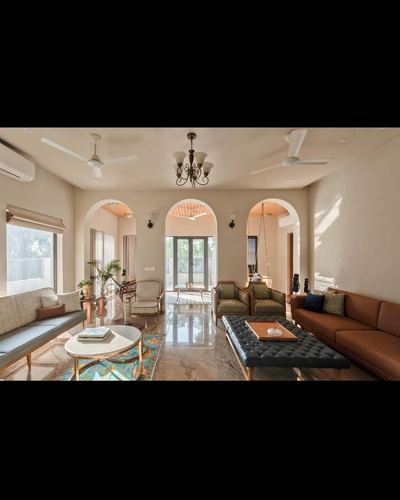 Living room with three arched doorways, marble floor, leather sofas and a hanging swing beyond