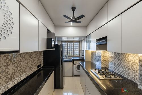 Galley kitchen with white cabinetry, black granite counters, patterned backsplash and ceiling fan, view toward window