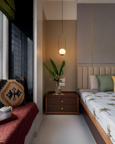 Bedroom nook with pendant light over dark wood nightstand beside window seat and upholstered bed