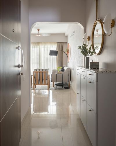 Foyer with arched doorway, brass mirror and console, opening into a bright living room