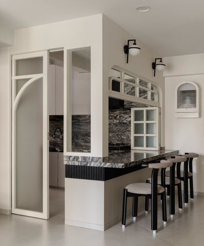 Curved white kitchen partition with arched glass door and dark stone breakfast counter