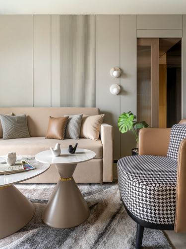 Neutral living room with beige sofa, houndstooth armchair, and fluted wall panel