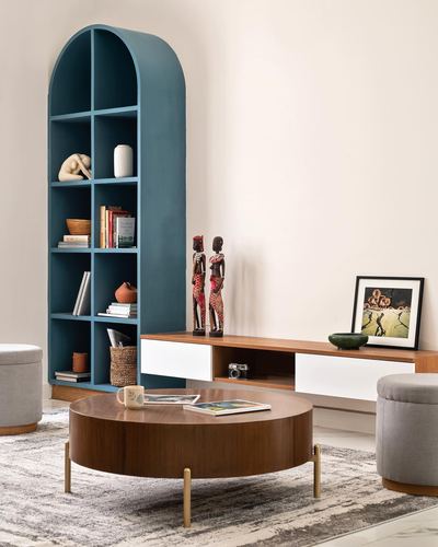 Living room with teal arched bookshelf, wooden console, and round brass-legged coffee table