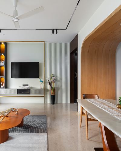 Living room with curved wood archway, fluted wall panel, orange coffee table, and floating tv unit