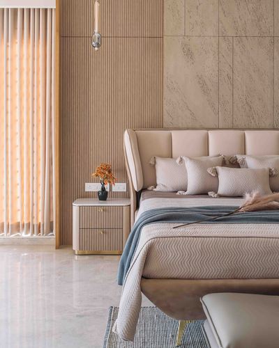 Beige bedroom with fluted wood panelling, stone accent wall, upholstered headboard and fluted nightstand