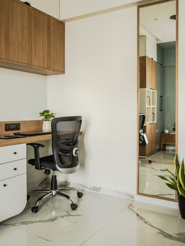 Small study nook with wall-mounted desk, mesh office chair, and full-length mirror on marble-look floor