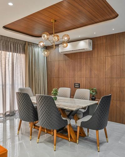 Dining room with marble-top table, quilted chairs, and wood-paneled ceiling and wall