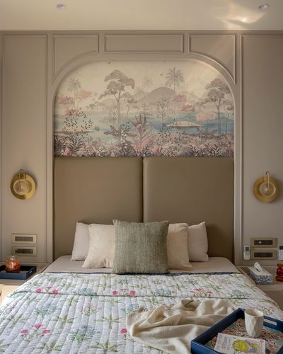 Bedroom headboard set in an arched wall niche with tropical mural wallpaper and brass sconces flanking it