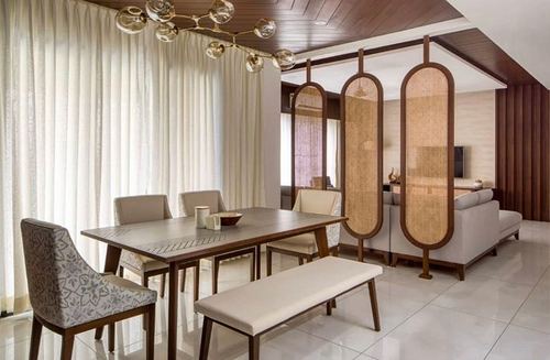 Dining room with wood table, bench, and cane partition screens dividing it from living area