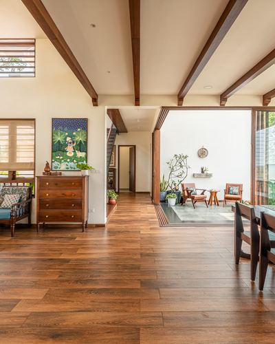 Living room with wood beams and floor opening through sliding doors to a small courtyard with seating