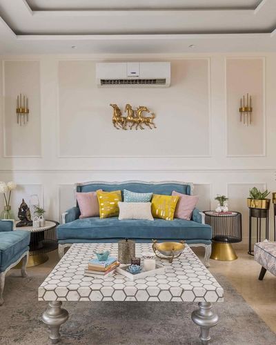 Cream living room with teal velvet sofa, brass horse wall art, and mosaic coffee table