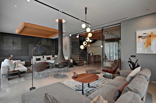 Contemporary living room with suspended fireplace, glass staircase, and cluster pendant lighting