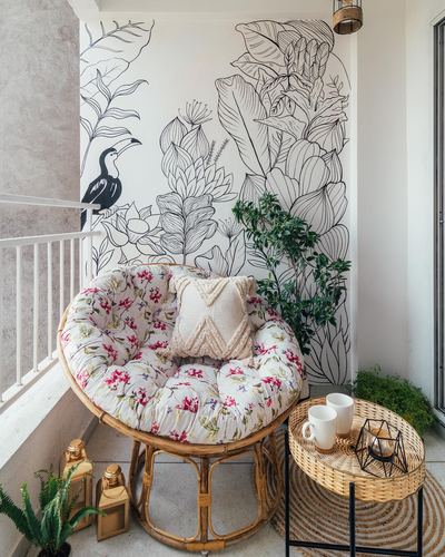 Balcony with rattan papasan chair, floral cushion, and hand-drawn botanical wall mural