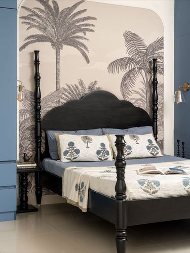 Black four-poster bed against arched palm-tree mural in blue-toned bedroom