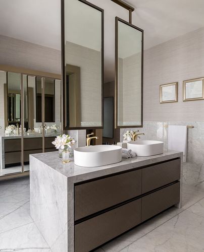 Marble double vanity with vessel sinks, gold fixtures, and ceiling-suspended mirrors in a luxury bathroom
