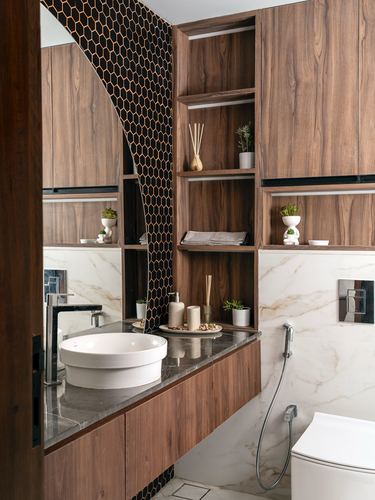 Bathroom vanity with wood cabinetry, black hexagonal tile accent, and round vessel sink