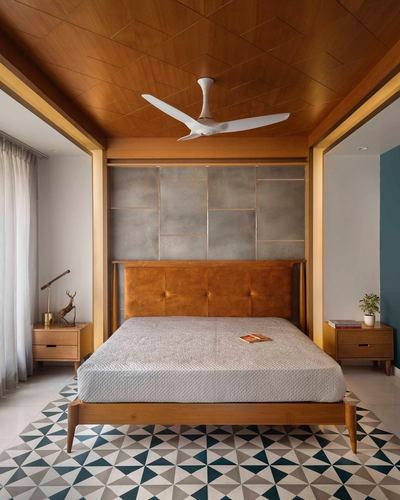 Bedroom with wood-paneled ceiling, tufted leather headboard, and geometric tiled floor