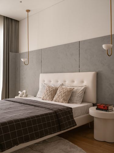 Minimalist bedroom with grey plaster wall, white tufted headboard, and brass pendant lights