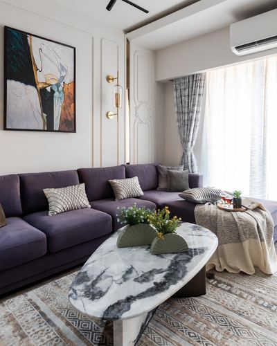 Purple velvet sectional sofa with oval marble coffee table in elegant living room