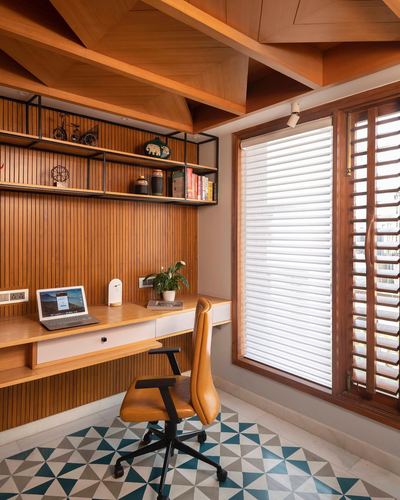 Wood-paneled study nook with floating desk, open shelves, patterned tile floor and shuttered window