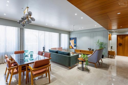 Open living-dining space with marble floor, teak ceiling accent and sputnik chandelier
