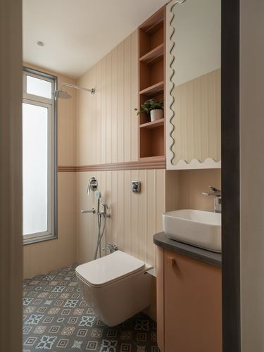 Small bathroom with fluted terracotta and cream panelling, patterned floor tile, and scalloped mirror cabinet