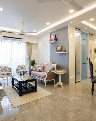 Living room with pink carved settee, floating shelves on grey wall, and glossy marble floor