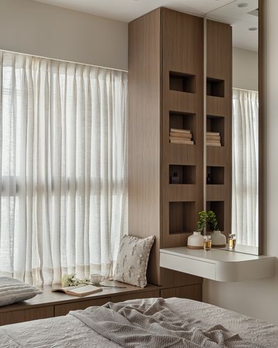 Bedroom corner with wood veneer shelving niches, mirror, floating vanity, and sheer-curtained window seat