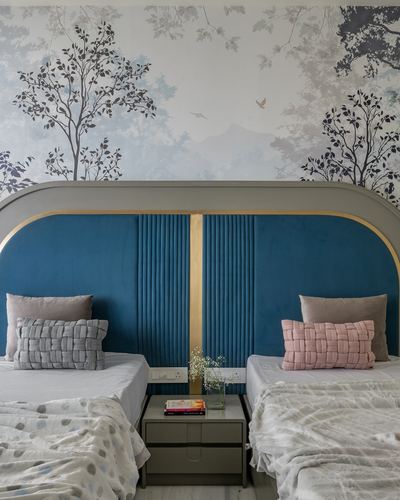 Twin beds with teal channel-tufted arched headboard against botanical mural wallpaper