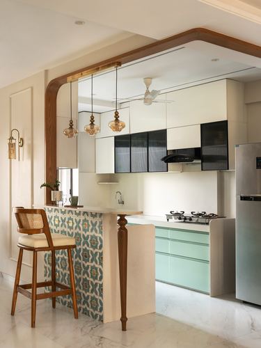 Kitchen with mint cabinetry, patterned tile counter front, wooden arch, amber pendant lights over bar seating