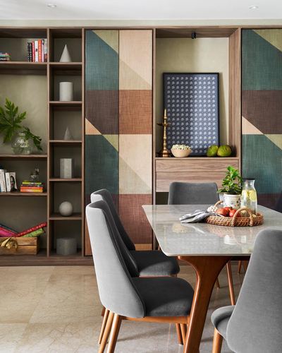 Dining area with geometric wardrobe panels, marble table, and grey velvet chairs