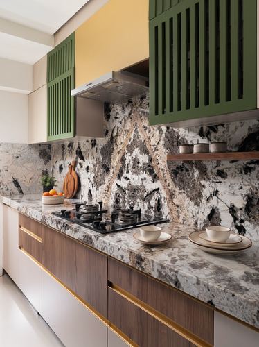 Kitchen counter with veined stone backsplash, olive green slatted cabinets, and wood-fronted drawers with brass handles