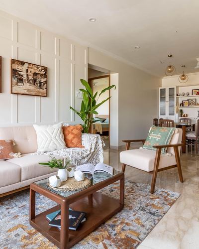 Living room with cream sofa, wooden coffee table, patterned rug and view into dining area
