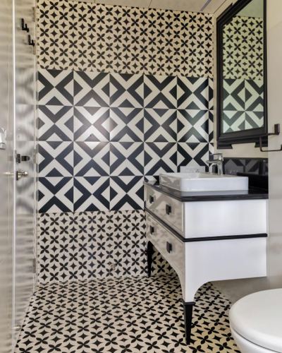 Black and white patterned tile bathroom with white console vanity and vessel sink